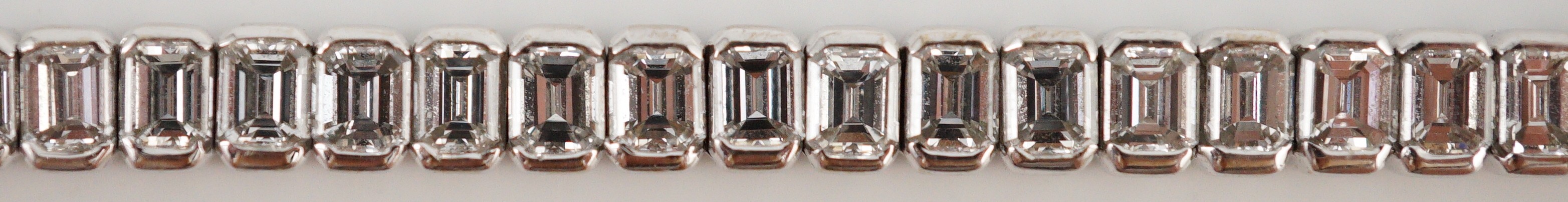 A modern 18ct white gold and emerald cut diamond set line bracelet